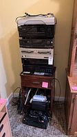 Full stack of audio components on top of wooden cabinet with cables below