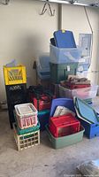 Overall view of assorted storage totes, crates and baskets stacked in garage