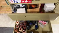 Drawer with assorted large and small thread spools