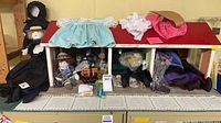 Overall view of dollhouse, dolls and clothing on roof
