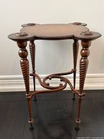 Full view of antique oak side table showing spiral legs, shaped top, brass studs, and stretcher