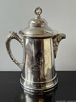 Full view of silver-plate water pitcher showing lid, handle, spout and pedestal base