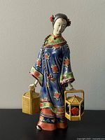 full view of porcelain lady figurine showing basket and lantern