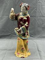 Front view of porcelain woman figurine pouring tea