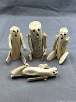 Group shot of all four Inuit antler figurines showing sizes and forms