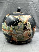 Front view of black porcelain ginger jar with lid showing warrior on horseback and flag details