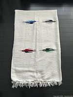 Full view of blanket showing bird motifs and fringe