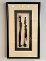 Full view of framed shadow box with two carved figures