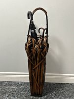 Front view of woven rattan umbrella stand with handle