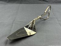 Full view of silver-plated Godinger scissor-style cake lifter tong