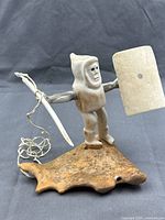 Full view of Inuit bone and antler hunter sculpture on antler base