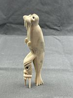 Front view of carved walrus atop dragon figure