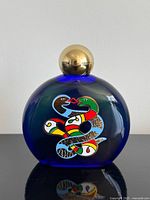 Full view of cobalt blue perfume bottle with gold cap