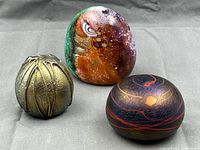Group shot of all three abstract art glass paperweights