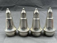 Front view of all four weighted sterling silver shakers.