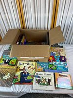 Overall view of cardboard box with children’s books displayed in front