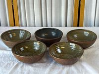 Group view of five stoneware bowls showing glaze and size