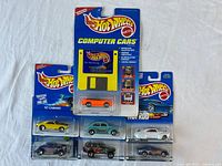 All seven sealed Hot Wheels items arranged on cloth