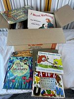 Open box showing numerous children’s books with visible titles