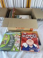 Open box showing many children's books and two titles in front