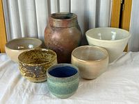 Group shot of six pottery pieces on cloth backdrop