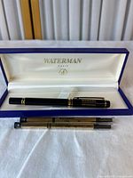 Open Waterman case displaying black gold-trim pen and two nib tubes