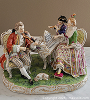 Full view of porcelain figural group showing all three musicians, harpsichord and dog