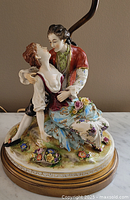 Full view of porcelain couple lamp on wood base