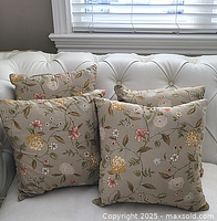 Four floral cushions on white tufted sofa