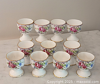 Ten Royal Albert Petit Point egg cups arranged on marble surface