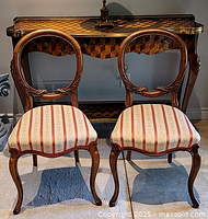 Pair of carved wood oval back accent chairs front view