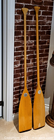 Full view of both 60" wooden paddles standing upright