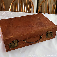 Top view of closed leather suitcase on table