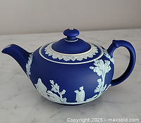 Right side view of blue Jasperware teapot showing handle, spout and white relief