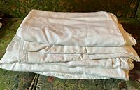 Stack of folded white linen damask tablecloths