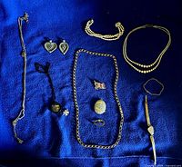 Overview of all jewellery pieces laid out on blue fabric