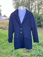 Front view of navy hunt jacket on hanger outdoors