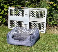 Dog bed and plastic gate outdoors
