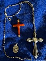 Full lot view showing carnelian cross, ornate silver cross with chain, St. Dismas medallion