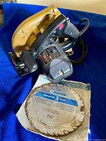 Gold/black Skilsaw circular saw and unopened 3-pack blade package