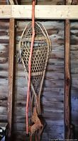 Wooden snowshoes, leather bindings and hiking staff hanging on wall