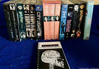 Row of VHS tapes and booklet on blue cloth