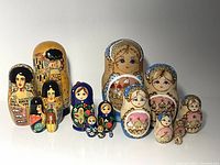 All three nesting doll sets lined up, showing sizes and painted themes