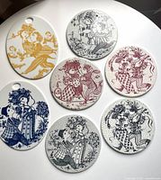 Seven Bjørn Wiinblad ceramic trivets on table