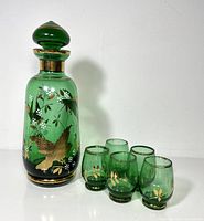 Full view of green decanter with stopper and five glasses