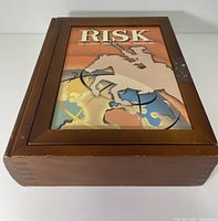 Closed wooden box with Risk artwork on lid