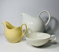 Group shot of white jug, white cup, yellow creamer