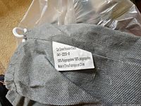 Gray drawstring bag showing fabric and content label for car cover