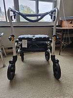 Front view showing frame, wheels, padded seat, handlebar