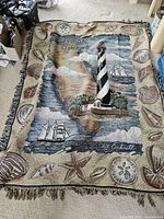 Woven Augustine Lighthouse throw blanket with seashell motifs